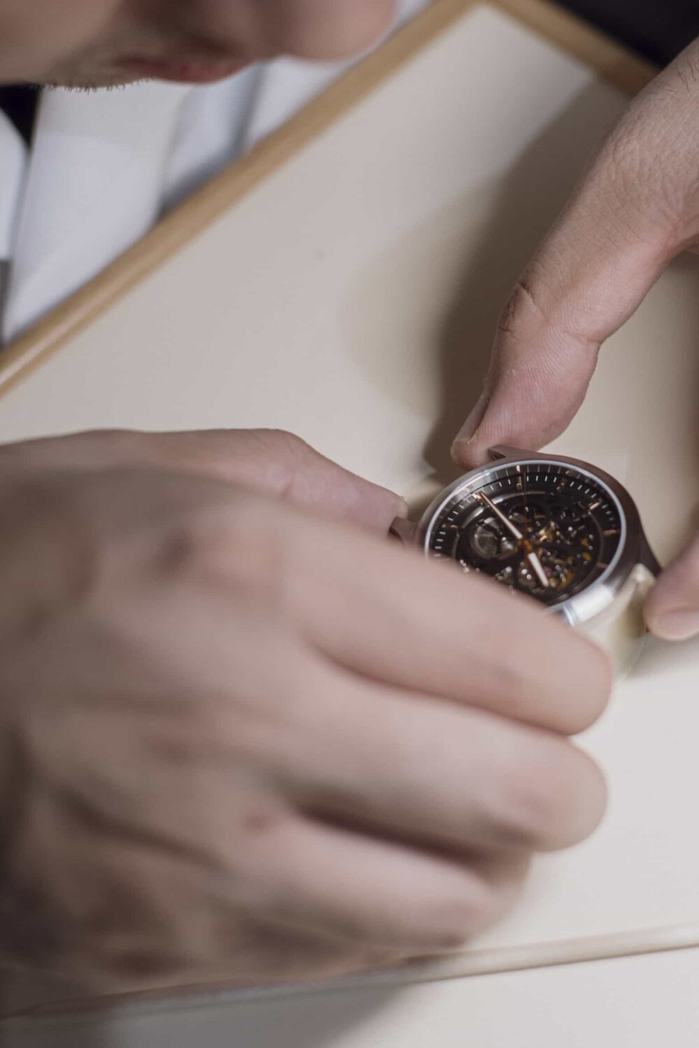 Participant closely examining a watch during assembly in a workshop.