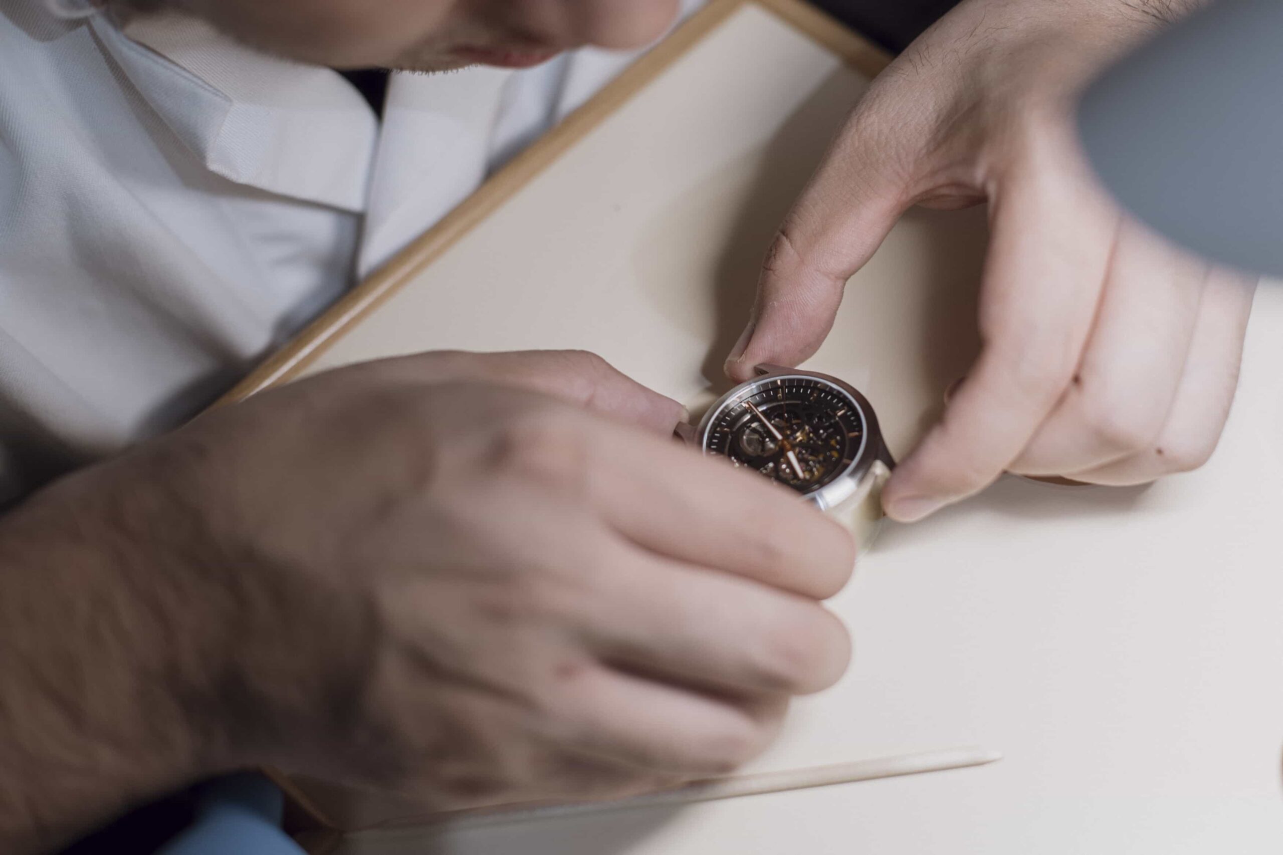 Participant closely examining a watch during assembly in a workshop.